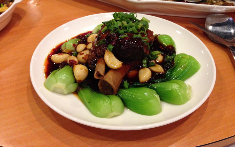 Tender pork shank with bok choy in a brown sauce with whole garlic cloves and scallion by Chengdu 23